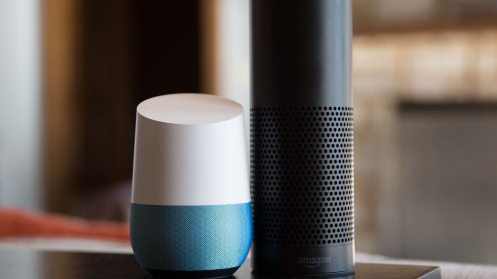 A picture of a Google Home next to an Echo